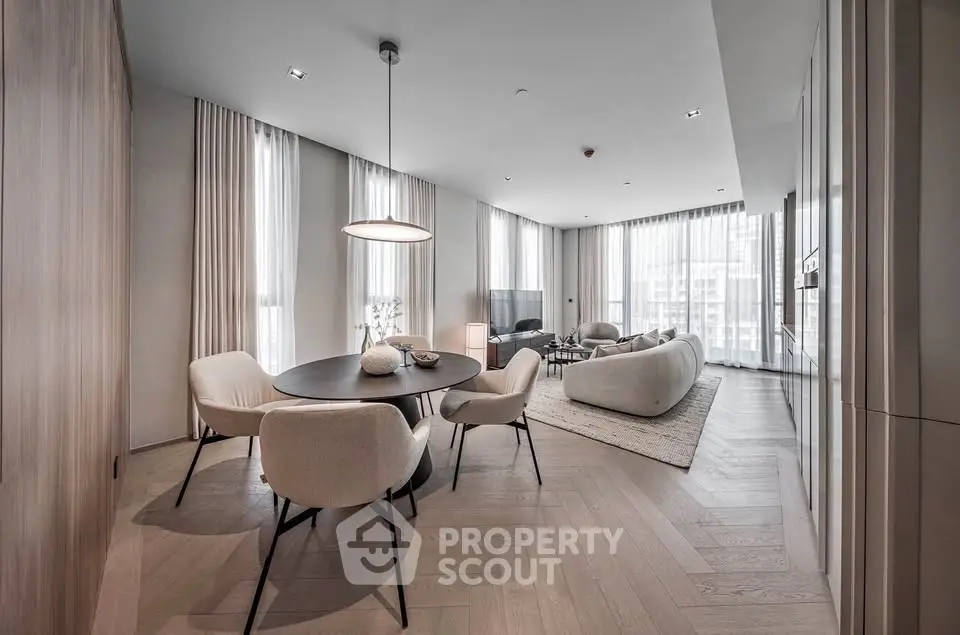 Elegant modern living room with stylish furniture and large windows offering city views.