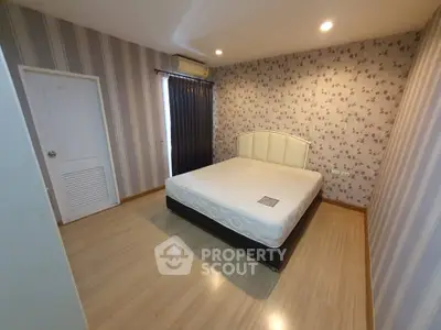 Cozy bedroom with floral wallpaper and modern lighting, featuring a comfortable bed and elegant design.