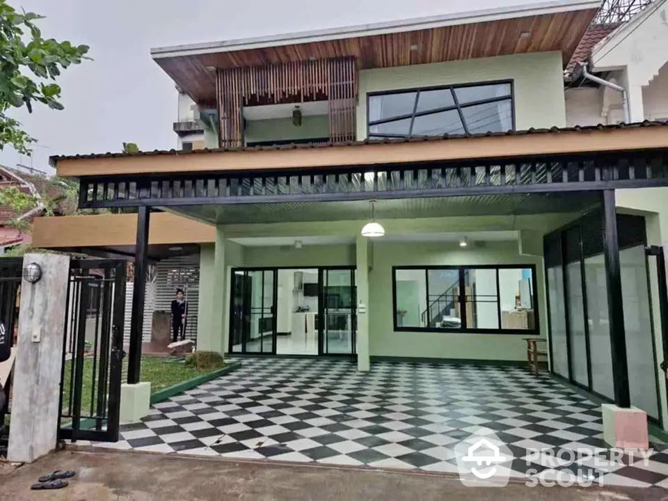 Modern two-story house with spacious checkered patio and large glass doors