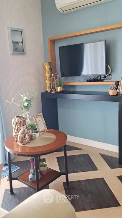 Stylish living room with modern decor and wall-mounted TV, featuring elegant parquet flooring and chic accents.