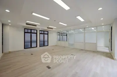Spacious modern office space with large windows and sleek flooring
