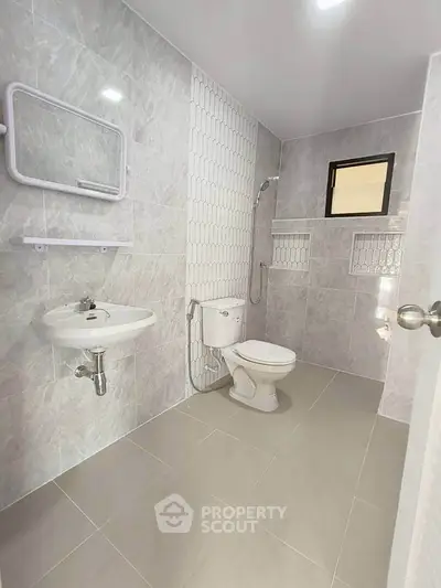 Modern bathroom with sleek tiles and compact design.