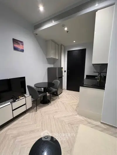 Modern compact living room with sleek kitchen and dining area, perfect for urban living.