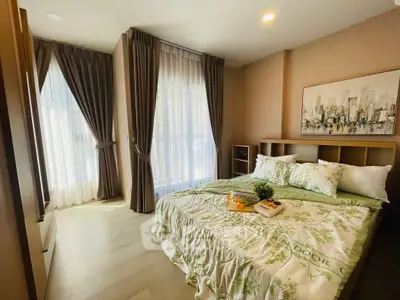 Cozy bedroom with elegant curtains and stylish bedding in a modern apartment.