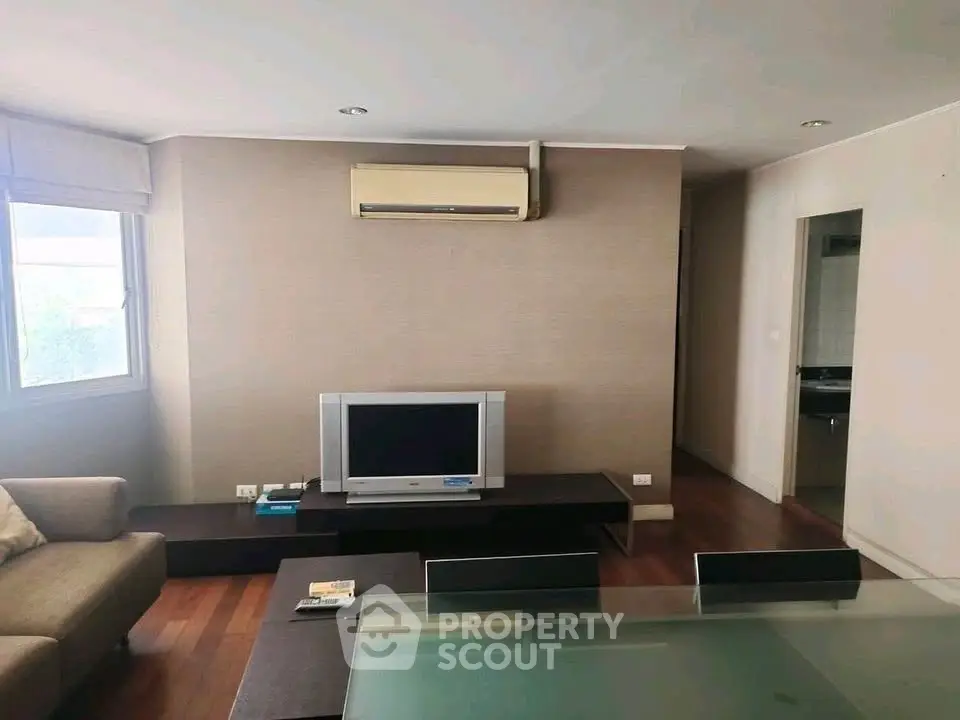 Modern living room with TV, air conditioning, and stylish furniture.