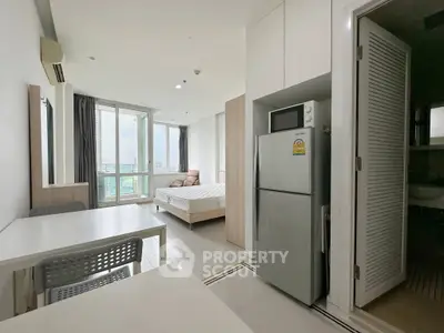 Modern studio apartment with open layout, featuring a cozy bedroom, dining area, and a balcony with city views.