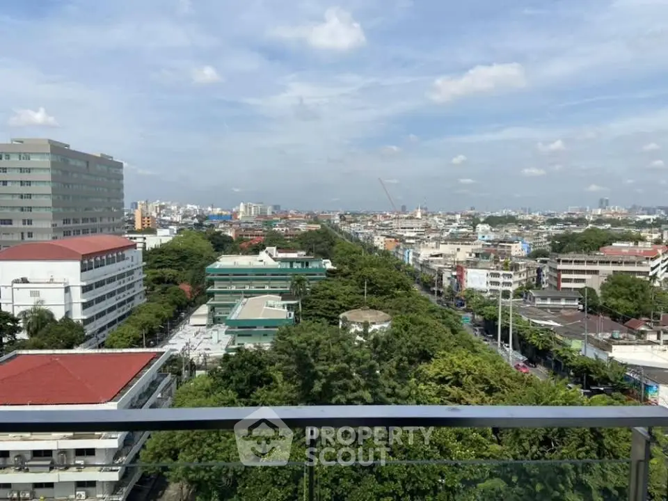 Stunning cityscape view from a high-rise balcony showcasing urban living with lush greenery and skyline.