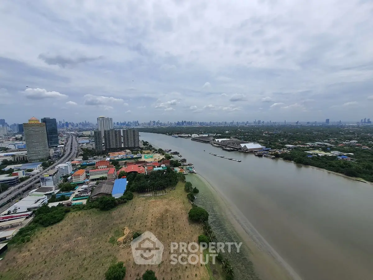 Stunning river view from high-rise building showcasing city skyline and lush greenery.