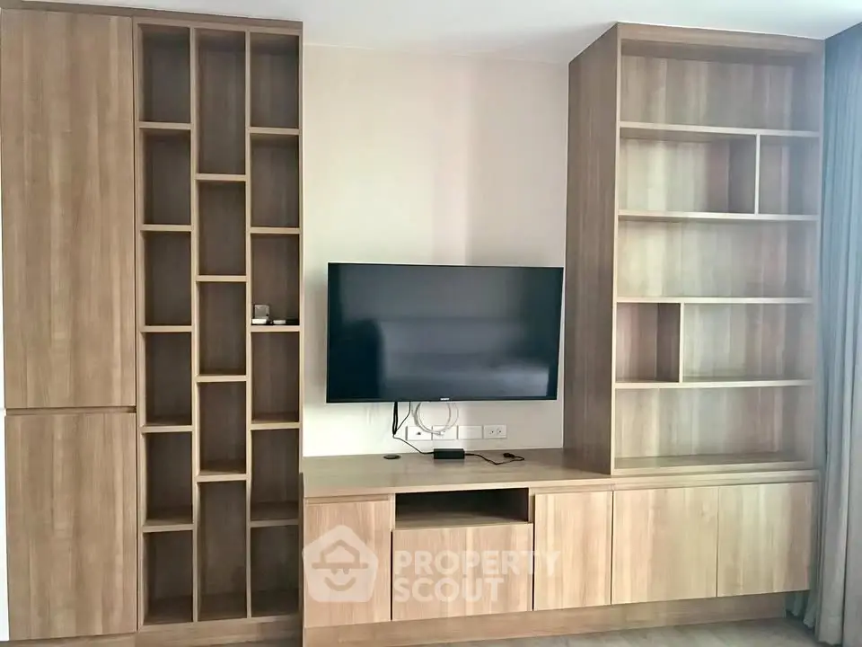 Modern living room with stylish wooden shelving and mounted TV, perfect for contemporary living.