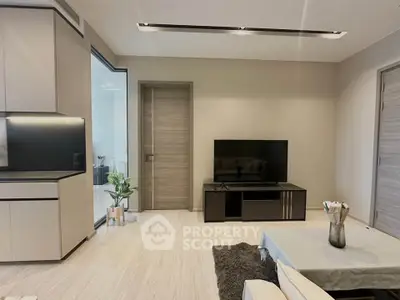 Modern living room with sleek design, featuring a flat-screen TV and stylish furniture, perfect for relaxation.