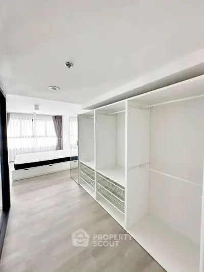 Spacious bedroom with built-in wardrobe and large windows for natural light.
