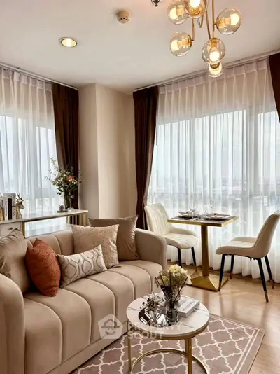Elegant living room with modern decor and dining area, featuring large windows and stylish lighting.