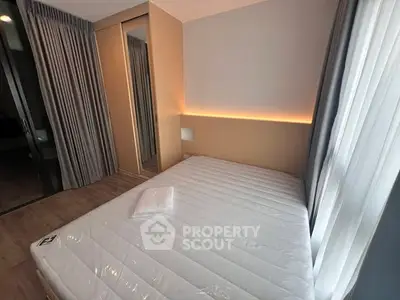 Modern bedroom with large window and built-in wardrobe, featuring sleek design and natural light.