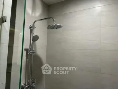 Modern bathroom with sleek shower fixtures and neutral tile design.