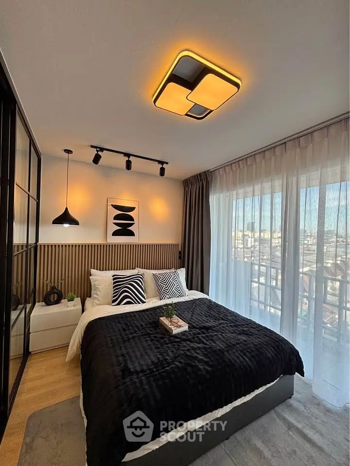 Modern bedroom with stylish lighting and large window offering city view