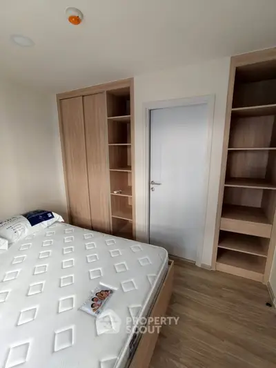 Modern bedroom with built-in wooden shelves and a comfortable bed, showcasing minimalist design.