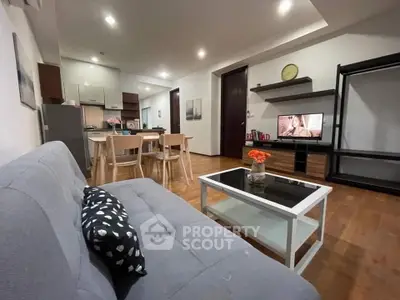 Modern open-layout living room with stylish furniture and kitchen area, perfect for cozy gatherings.