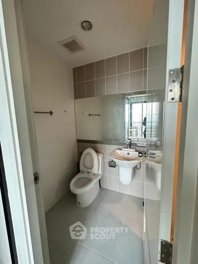 Modern bathroom with sleek design and large mirror in a contemporary apartment.