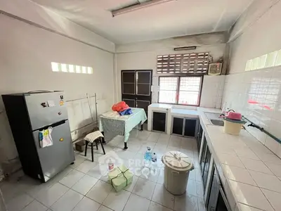 Spacious kitchen with tiled countertops and ample natural light.
