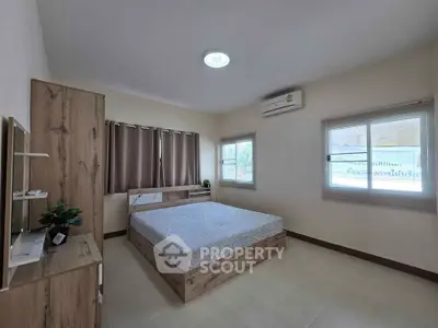 Spacious bedroom with modern wooden furniture and large windows