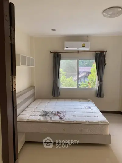 Cozy bedroom with large window and air conditioning unit