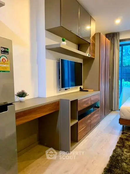 Modern living room with sleek TV unit and stylish decor in a cozy apartment.