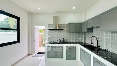Modern kitchen with sleek cabinetry and open layout, featuring a gas stove and stylish backsplash.