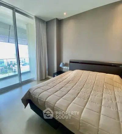 Spacious bedroom with large window offering stunning city views and modern decor.