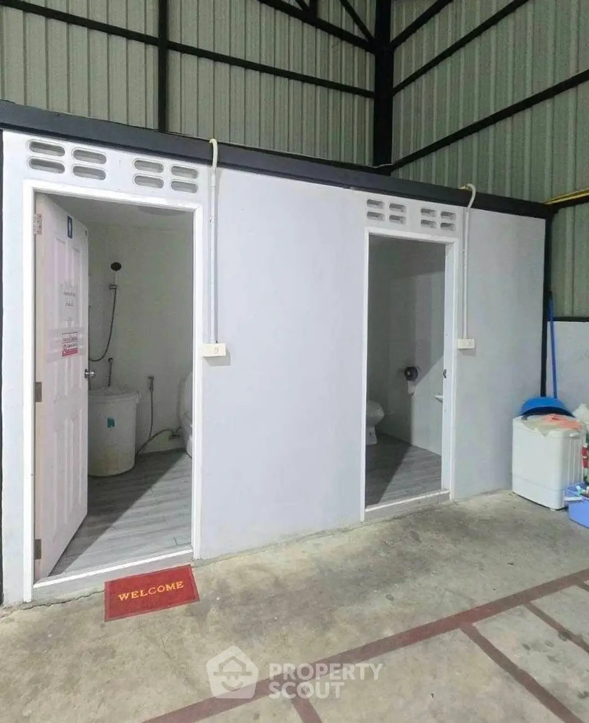 Industrial-style bathroom with two separate stalls and a welcome mat.