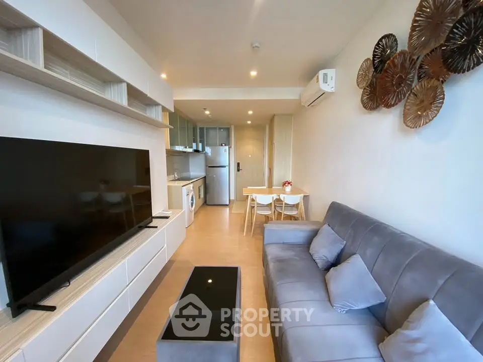 Modern living room with sleek furniture and open kitchen layout in a stylish apartment.