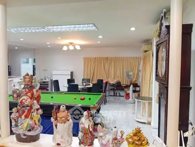 Spacious living room with pool table and decorative statues, ideal for entertainment and relaxation.