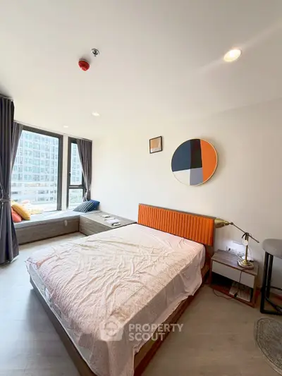 Modern bedroom with stylish decor and large window offering city view