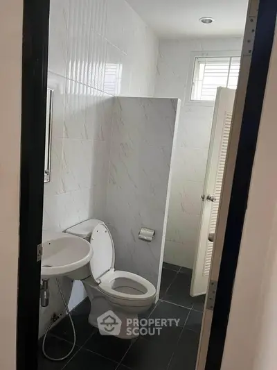 Compact bathroom with modern fixtures and natural light from a small window.