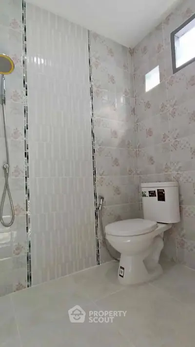 Modern bathroom with floral tiles and shower in real estate property