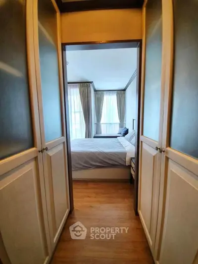 Elegant bedroom with wooden flooring and ample natural light