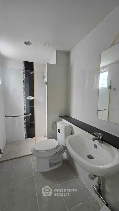 Modern bathroom with sleek fixtures and walk-in shower in a contemporary home.