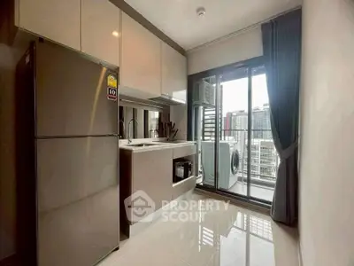 Modern kitchen with sleek appliances and balcony view in urban apartment