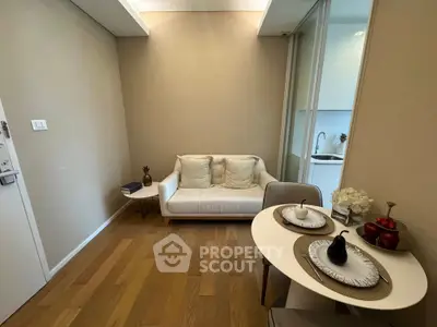 Cozy living room with modern decor and dining area, featuring wooden flooring and neutral tones.