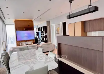 Luxurious modern living room with open kitchen and marble dining table, featuring sleek design and city view.