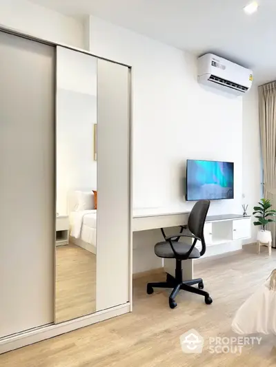 Modern bedroom with sleek furniture and wall-mounted TV in a stylish apartment