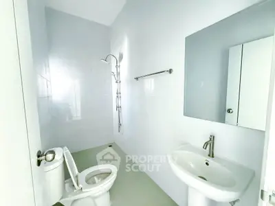 Modern minimalist bathroom with sleek fixtures and bright white tiles.