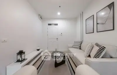 Modern living room with stylish decor and neutral tones, featuring a comfortable sofa and elegant wall art.