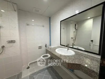Modern bathroom with granite countertop and large mirror