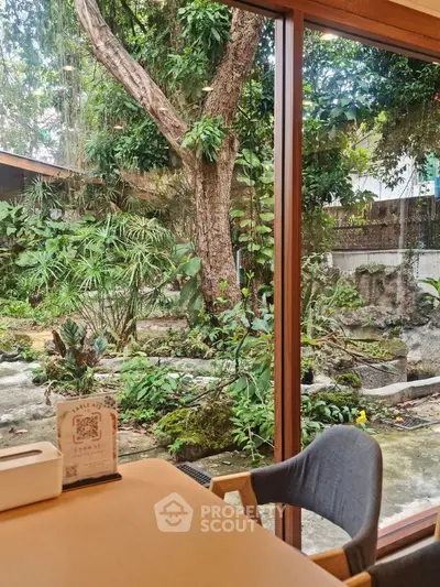 Charming garden view from cozy interior with wooden accents and lush greenery
