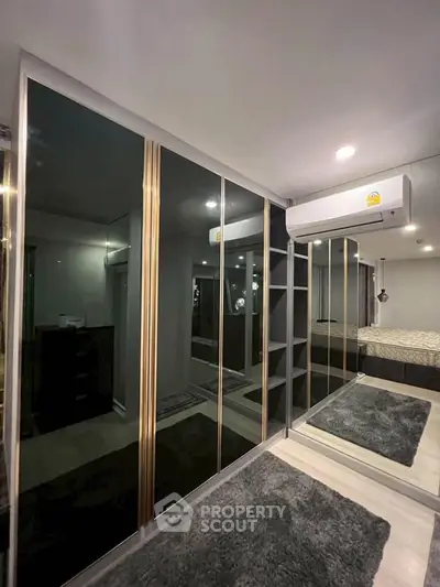 Modern bedroom with mirrored wardrobe and air conditioning unit