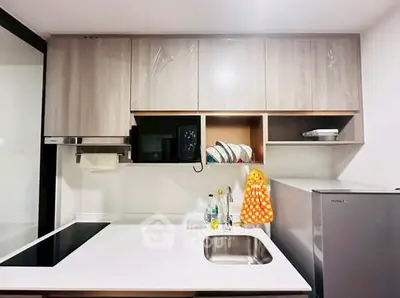 Modern kitchen with sleek cabinetry and compact appliances, featuring a minimalist design.