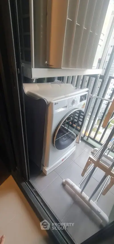 Compact balcony with washing machine and drying rack in modern apartment