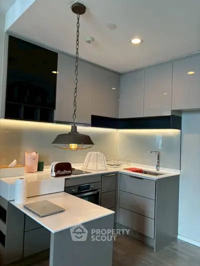 Modern kitchen with sleek cabinetry and stylish lighting in a contemporary apartment.