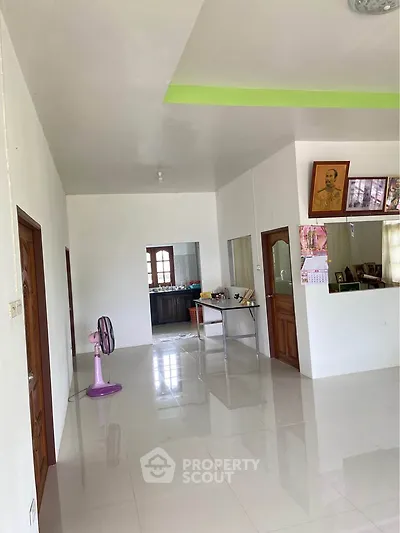 Spacious open layout living area with glossy tiled floors and natural light.