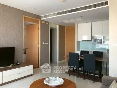Modern living room with dining area and sleek kitchen in open layout apartment.